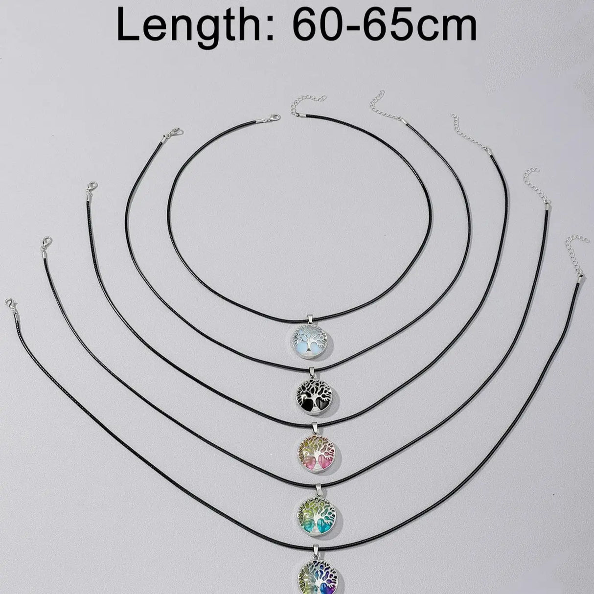 Set of black necklaces with colorful pendants on a light gray background