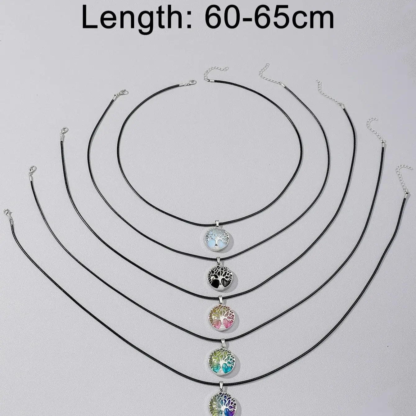 Set of black necklaces with colorful pendants on a light gray background