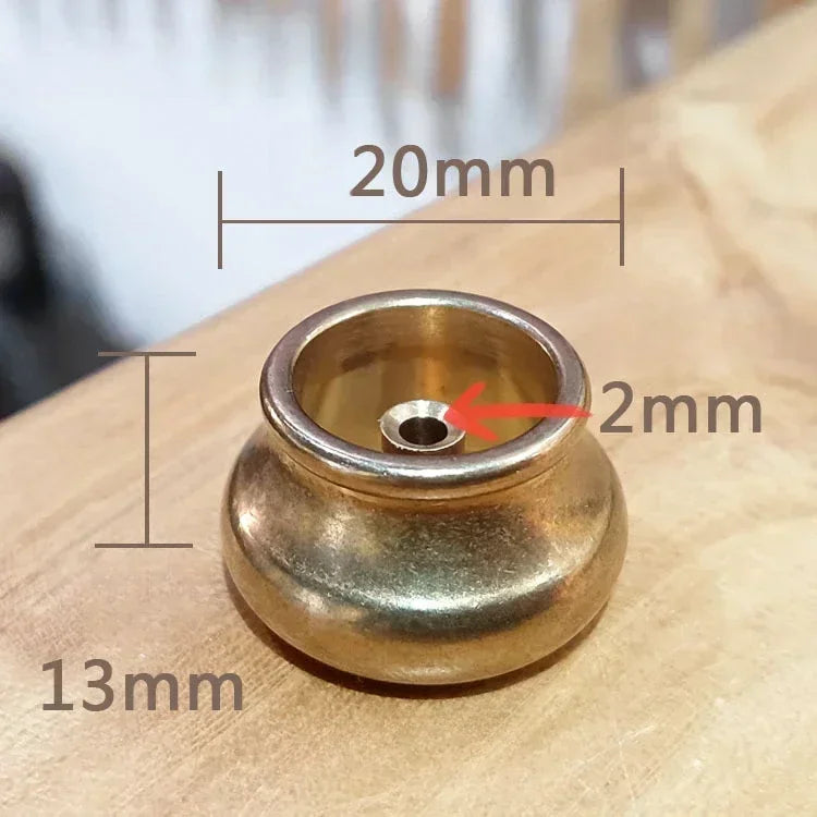 Brass incense holder with measurements on a wooden surface