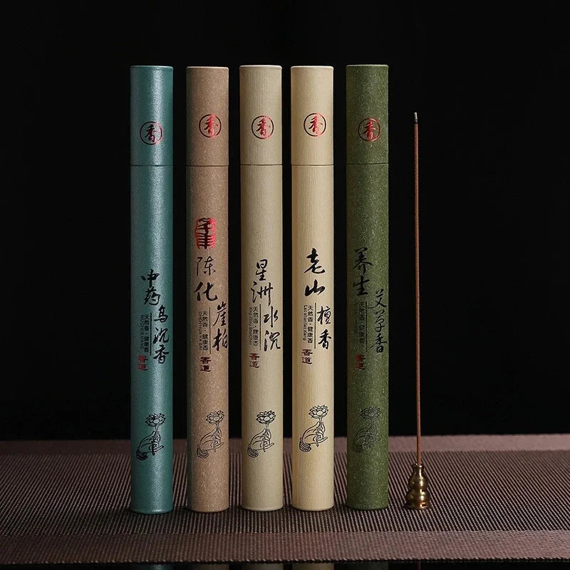 Five incense sticks in cylindrical containers with text and symbols on a dark background