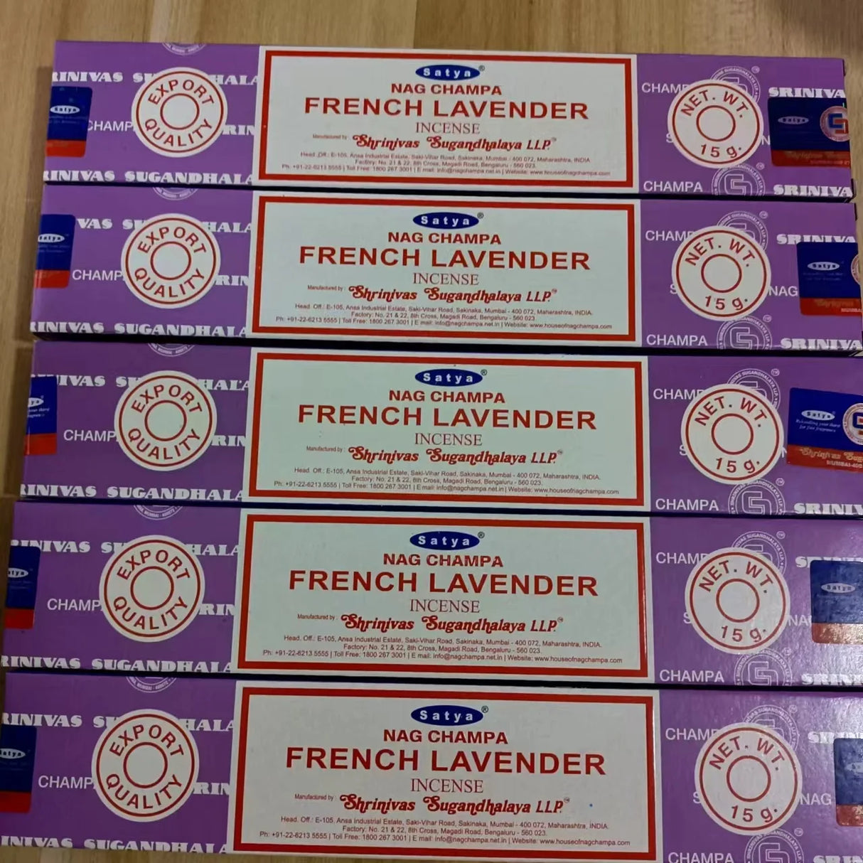 Multiple boxes of Nag Champa French Lavender incense on a wooden surface