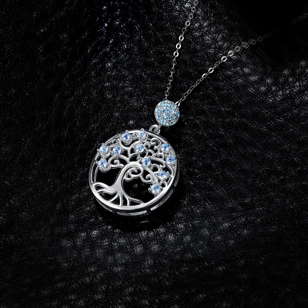 Silver tree of life pendant with blue gemstones on a black textured background