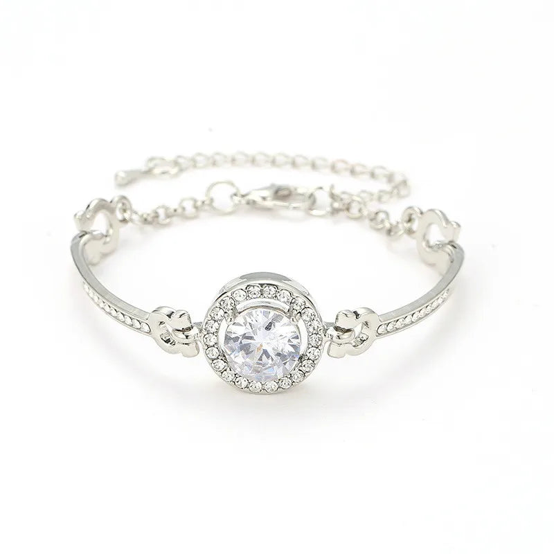 Silver bracelet with a large central gemstone on a white background