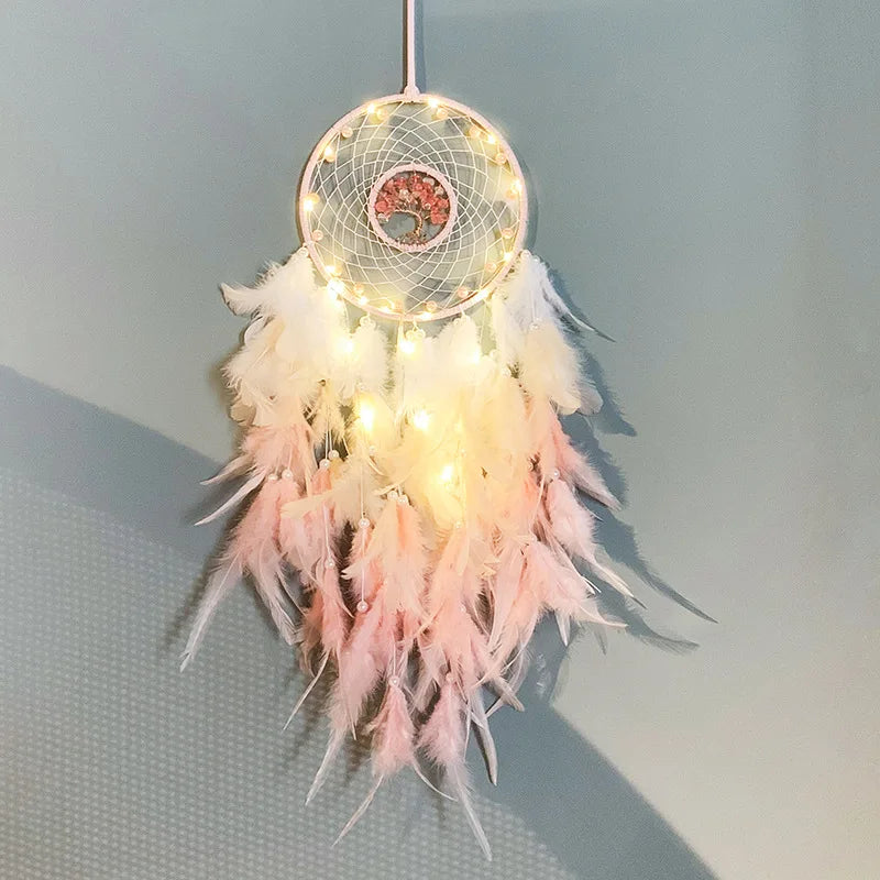 Decorative dreamcatcher with feathers and lights on a plain background
