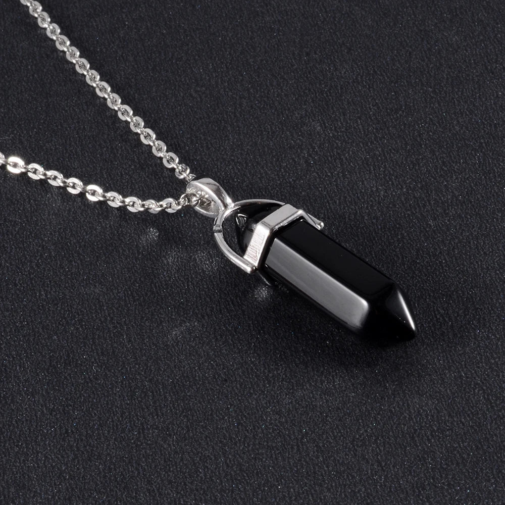 Black crystal pendant on a silver chain against a black background