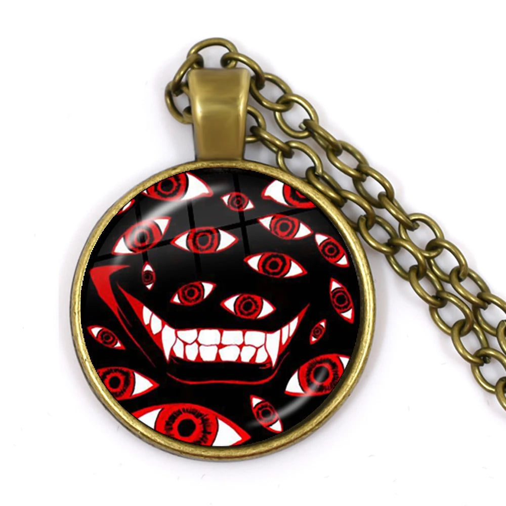Pendant with a design of a face with red eyes and a gold chain on a white background