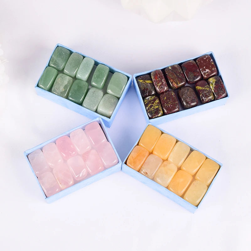 Four boxes of assorted colorful stones on a white background