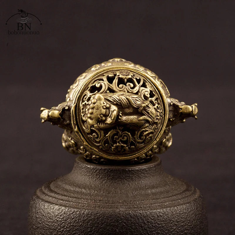 Decorative bronze ring with intricate design on a dark background