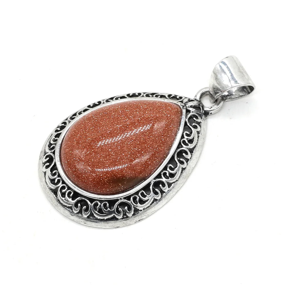 Silver pendant with a brown stone on a white background