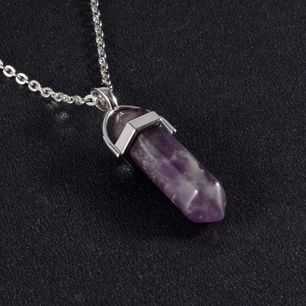 Purple crystal pendant on a silver chain against a black background