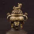 Bronze incense burner with intricate designs on a dark background