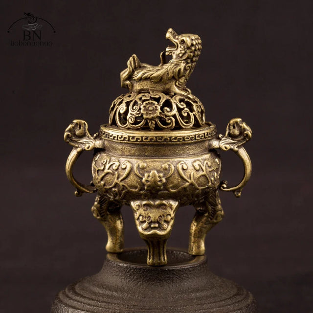 Bronze incense burner with intricate designs on a dark background