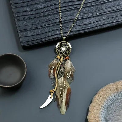 Necklace with feather pendant on a dark surface