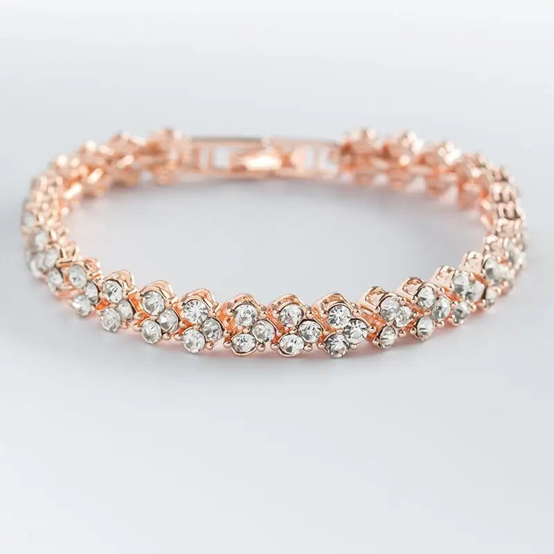Rose gold bracelet with clear stones on a light gray background