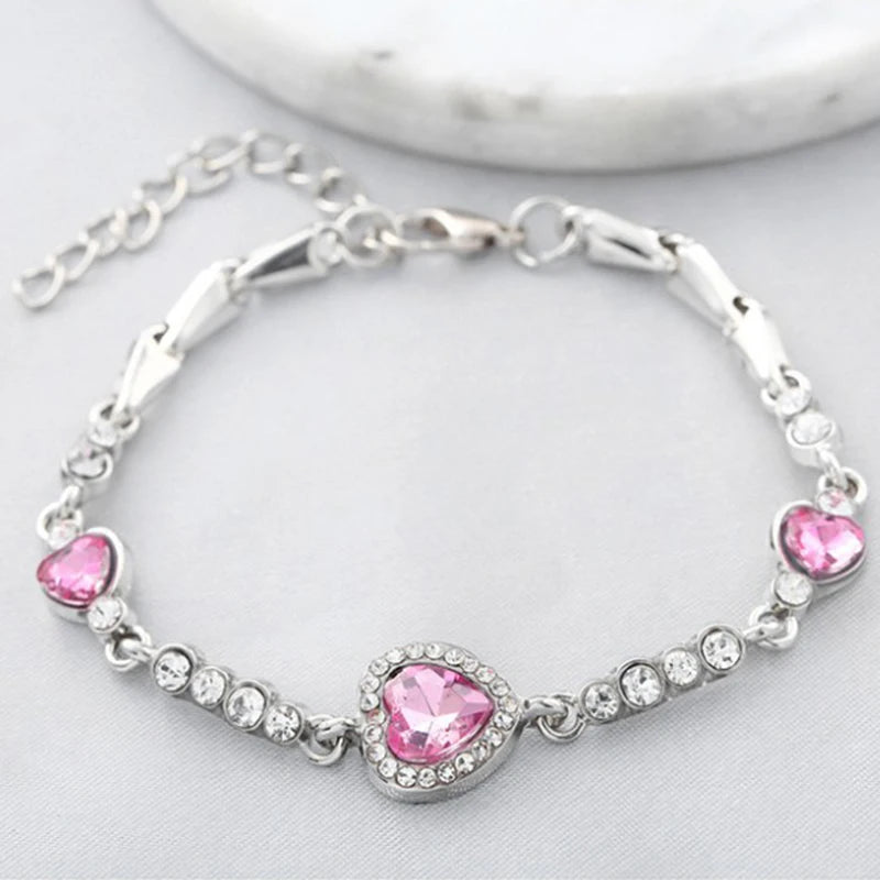 Silver bracelet with pink heart-shaped stones on a light background