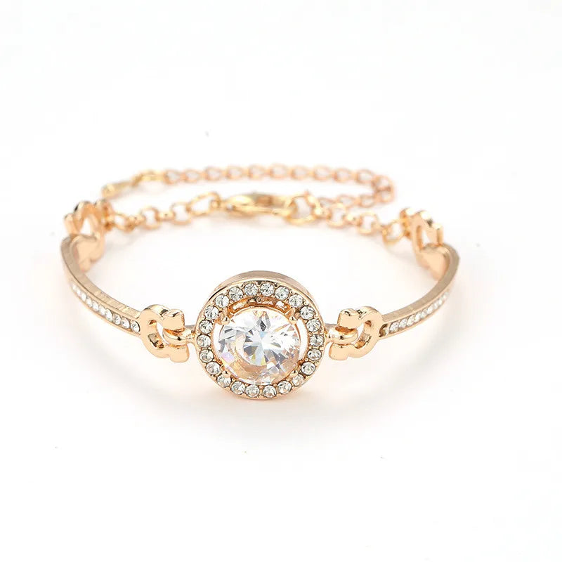 Gold bracelet with a large crystal on a white background