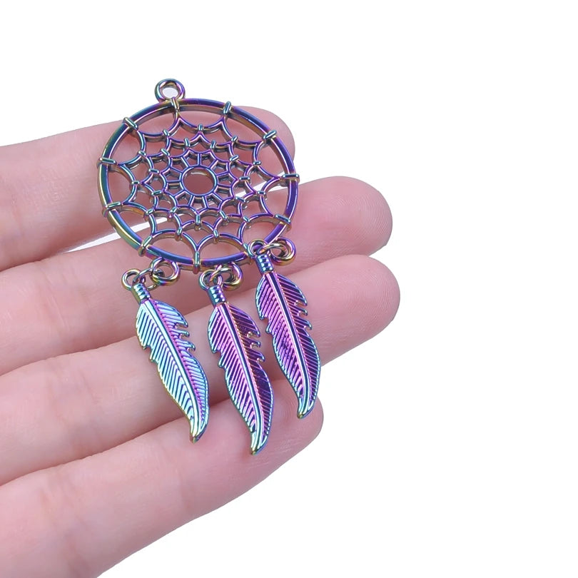 Colorful dreamcatcher pendant with feathers held in a hand against a white background