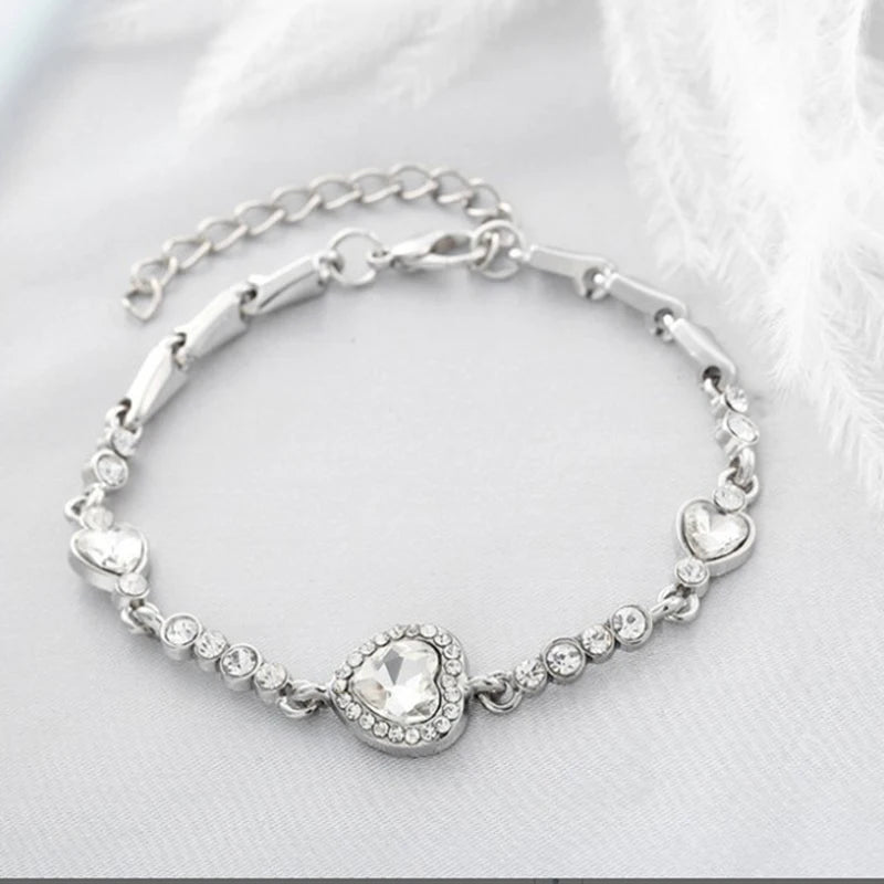 Silver bracelet with heart-shaped charms on a white background