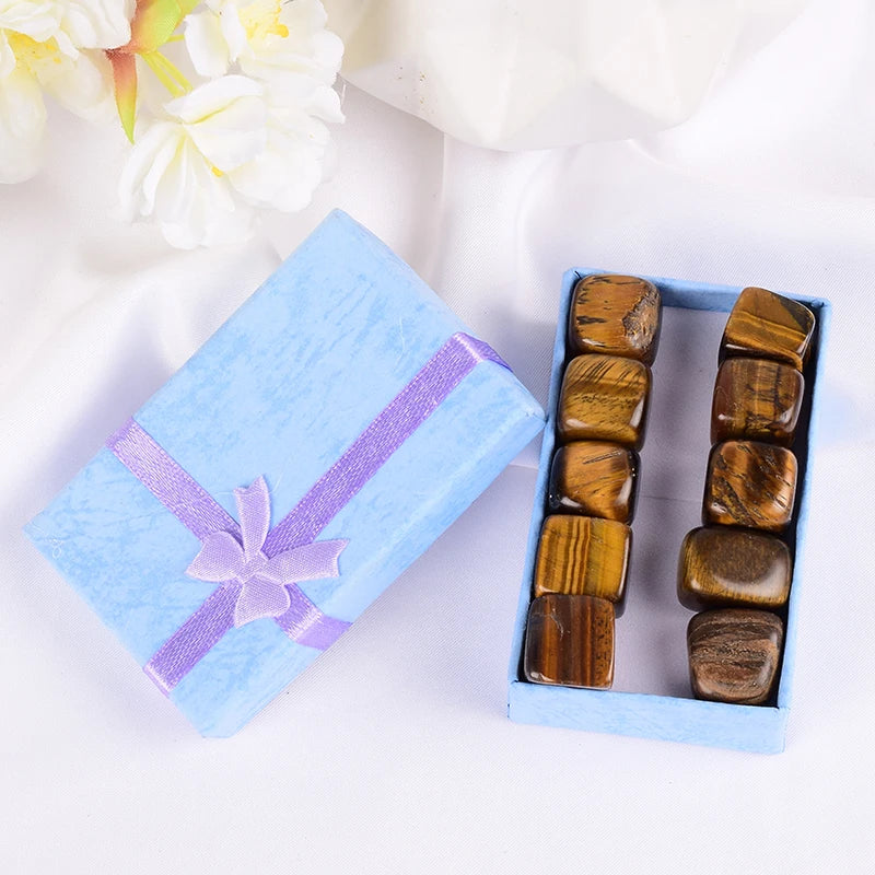 Box of tumbled stones with a decorative ribbon on a white background
