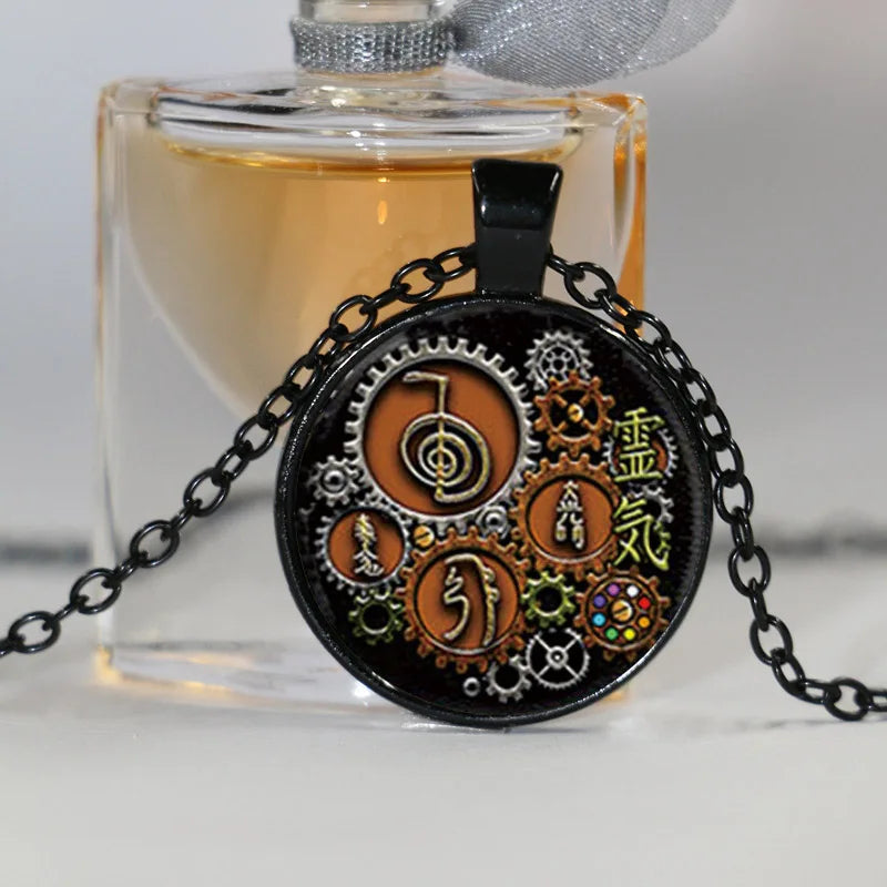 Necklace with intricate design in front of a perfume bottle