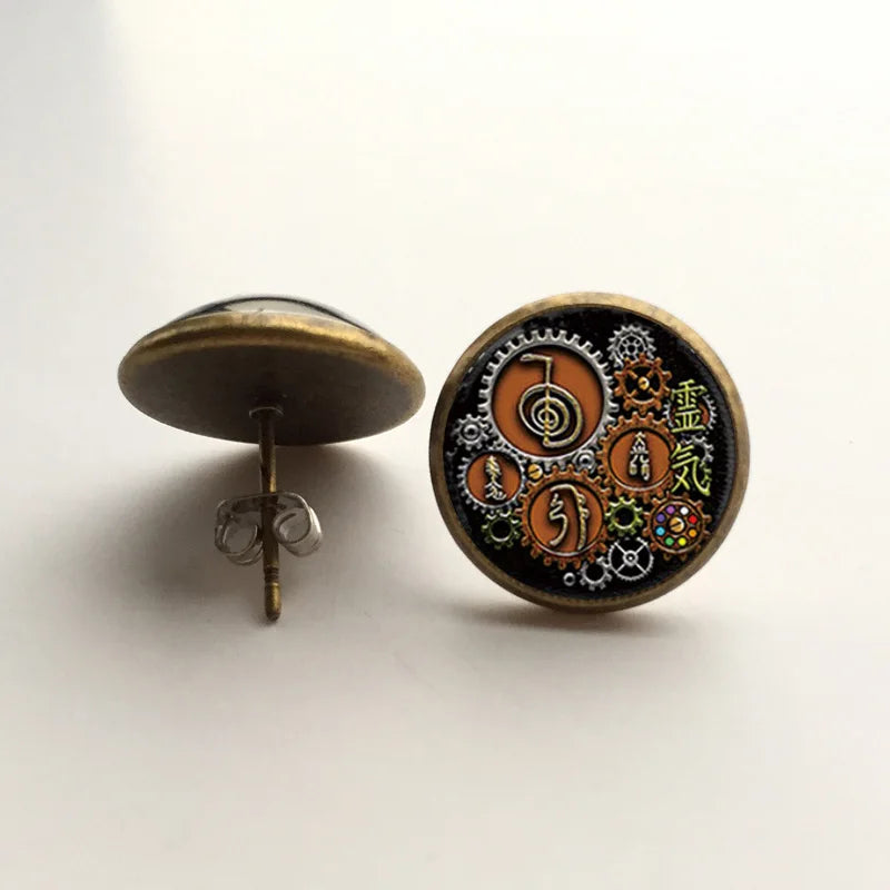 Steampunk-style earrings with intricate designs on a white background