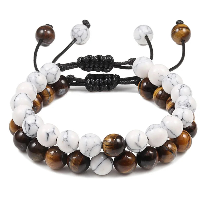 Stack of three beaded bracelets with white, brown, and black beads on a white background
