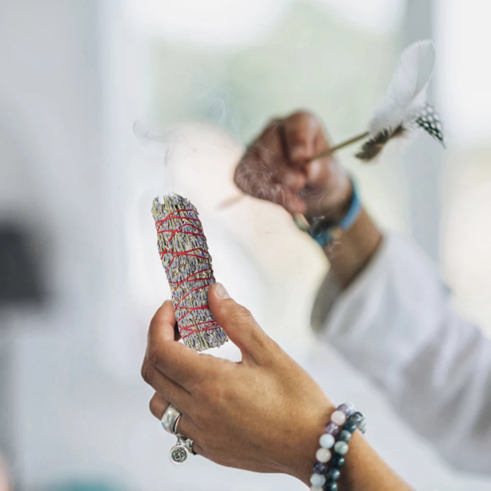 Hand holding a colorful incense with blurred background