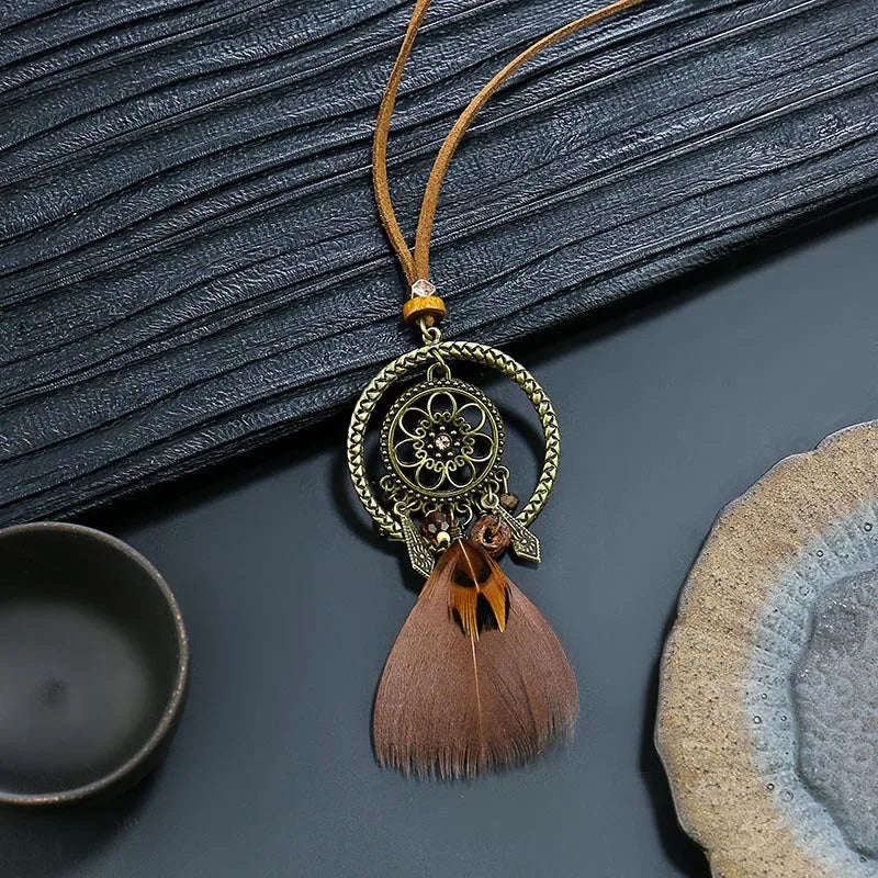 Decorative pendant with feather on a textured surface