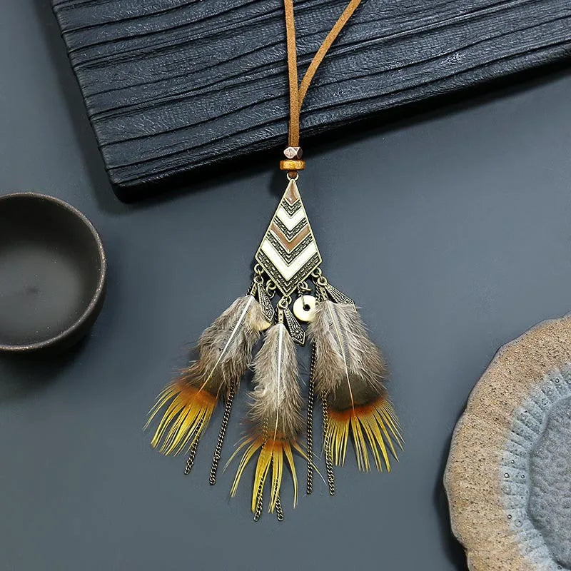 Feathered pendant necklace with geometric design on a dark surface