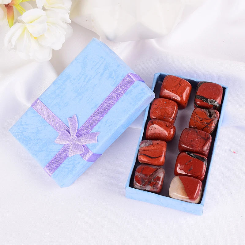Box of red stones with a blue gift box on a white background