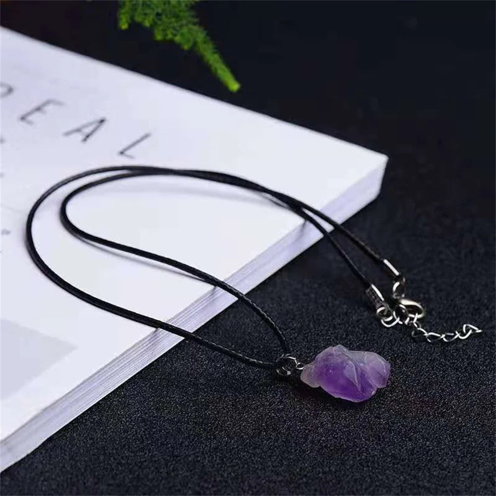 Necklace with a purple crystal pendant on a dark surface