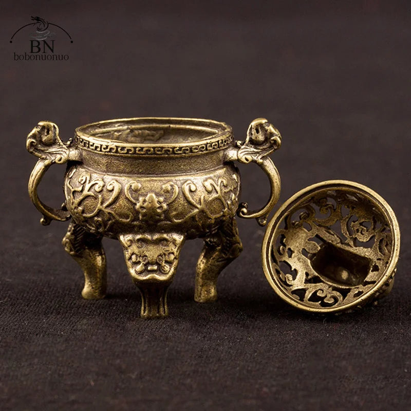 Decorative bronze incense burner with intricate designs on a dark background