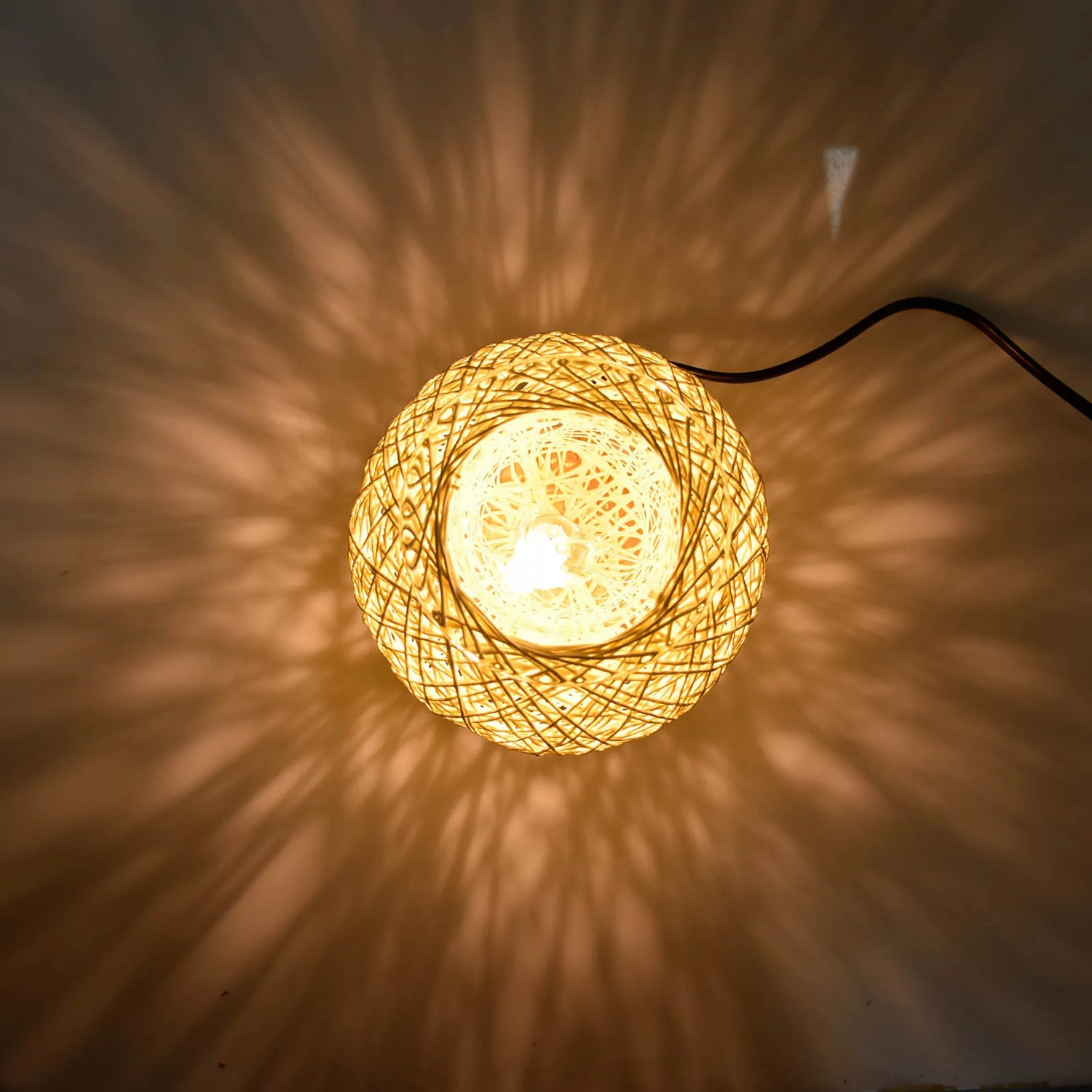 Woven string light casting a warm glow on a wall