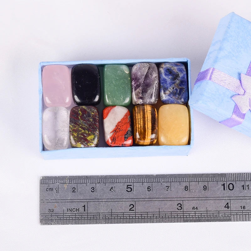 Box of colorful stones with a ruler for scale on a white background
