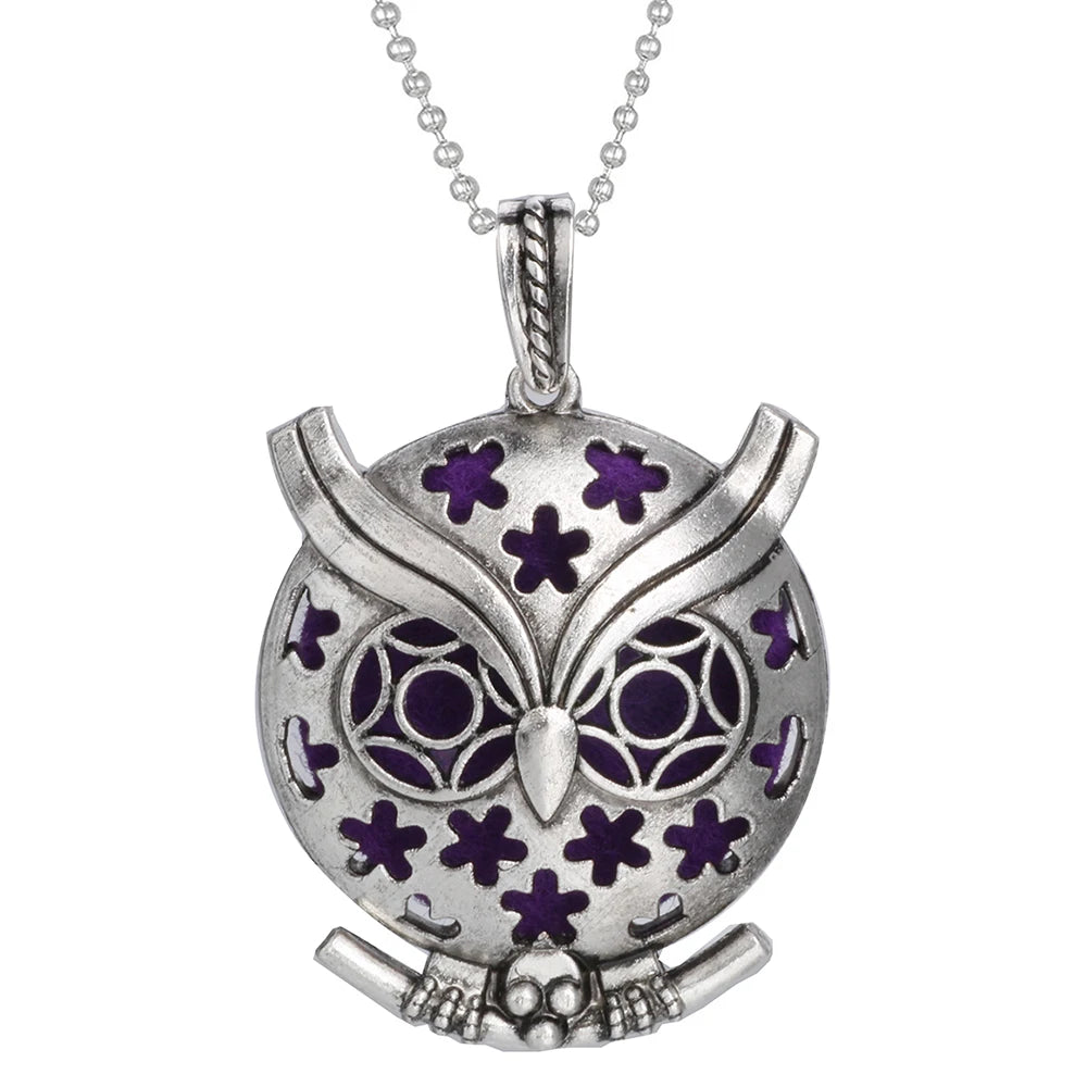 Silver owl pendant with purple accents on a white background