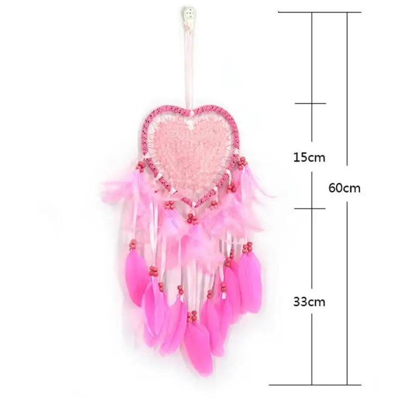 Pink heart-shaped dreamcatcher with feathers and measurements on a white background
