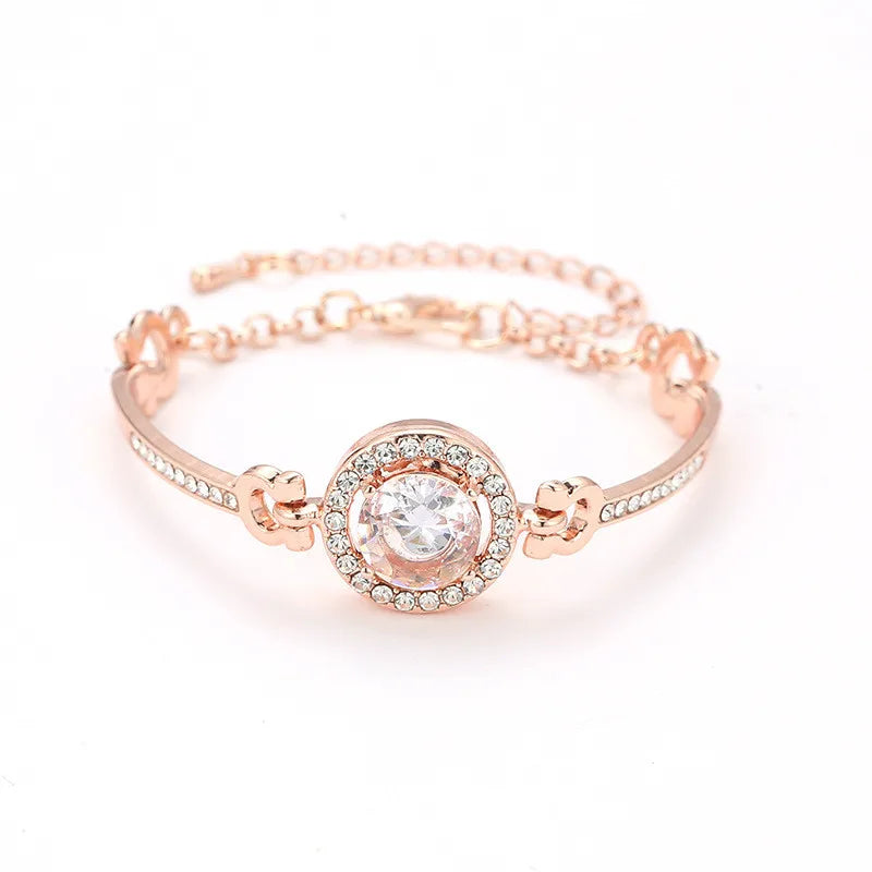 Rose gold bracelet with a central gemstone on a white background