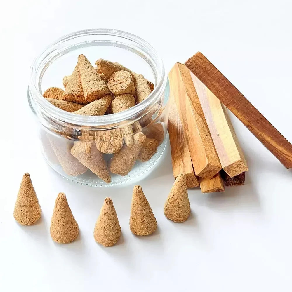 Incense cones in a glass jar with incense sticks on a white background