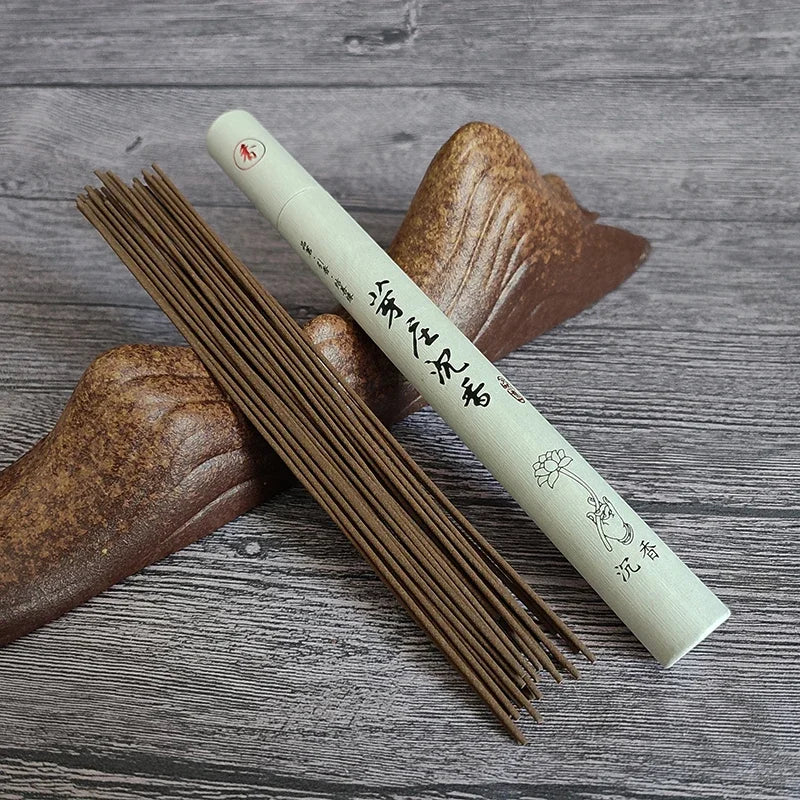Incense sticks with a cylindrical container on a wooden surface