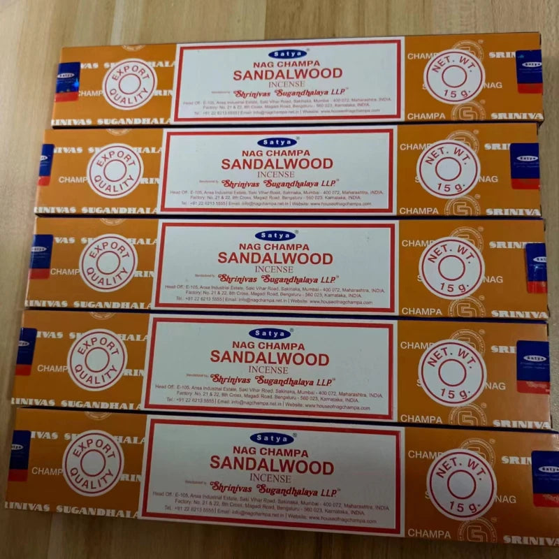 Multiple boxes of Nag Champa Sandalwood incense on a wooden surface