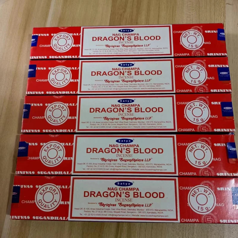 Multiple boxes of Nag Champa Dragon's Blood incense on a wooden surface
