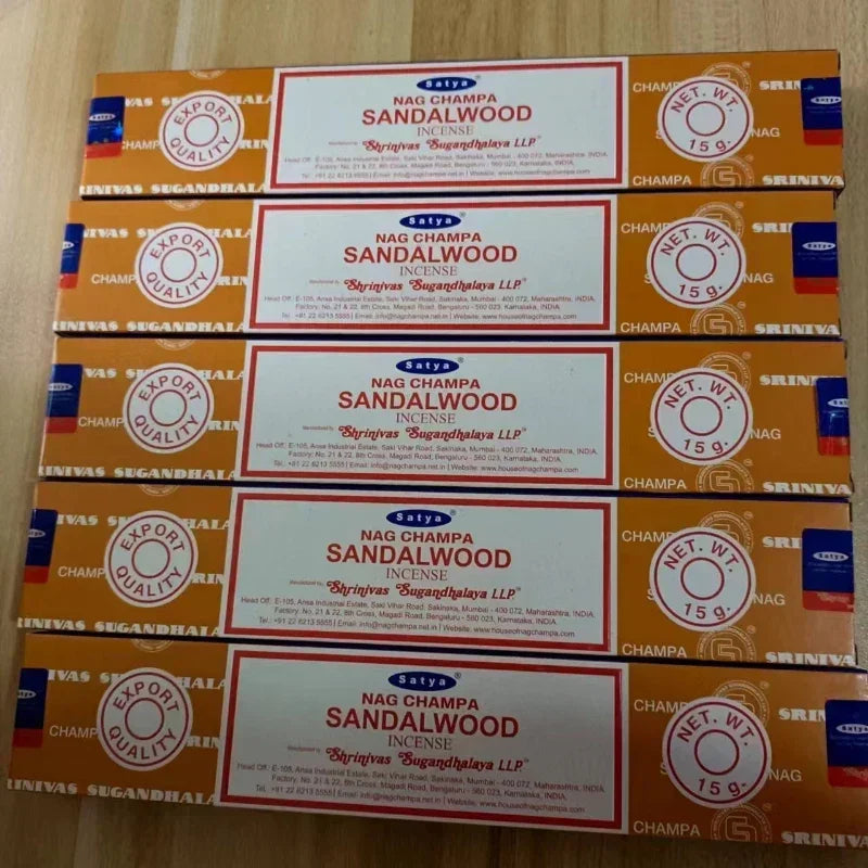 Multiple boxes of Nag Champa Sandalwood incense on a wooden surface