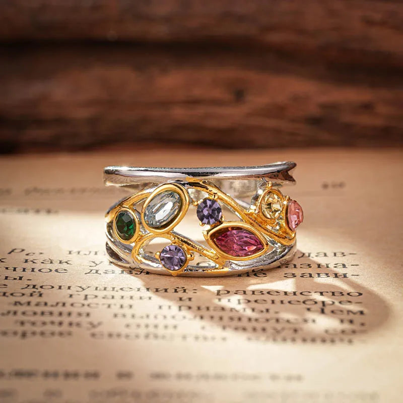 Decorative ring with colorful gemstones on a textured surface
