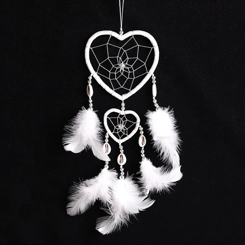 Heart-shaped dreamcatcher with white feathers on a black background