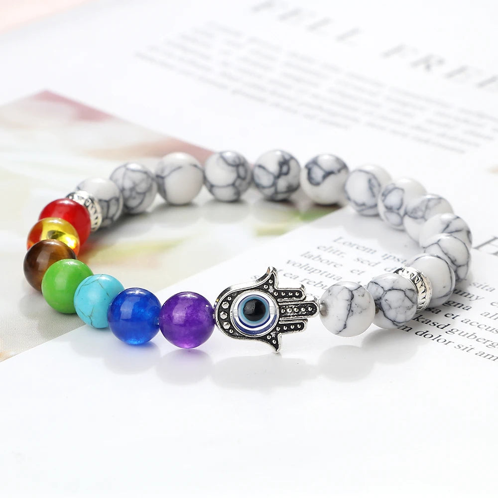 Multicolored beaded bracelet with a Hamsa hand charm on a newspaper background