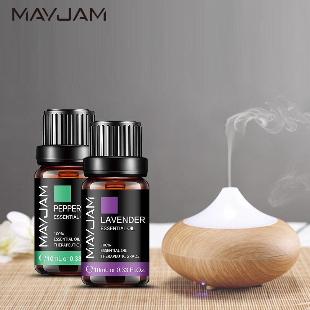 Two Mayjam essential oil bottles with a diffuser on a wooden surface.