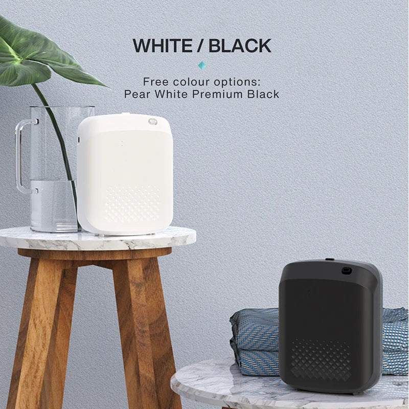 White humidifier on a wooden table with a black air purifier on a marble surface, against a light gray wall.