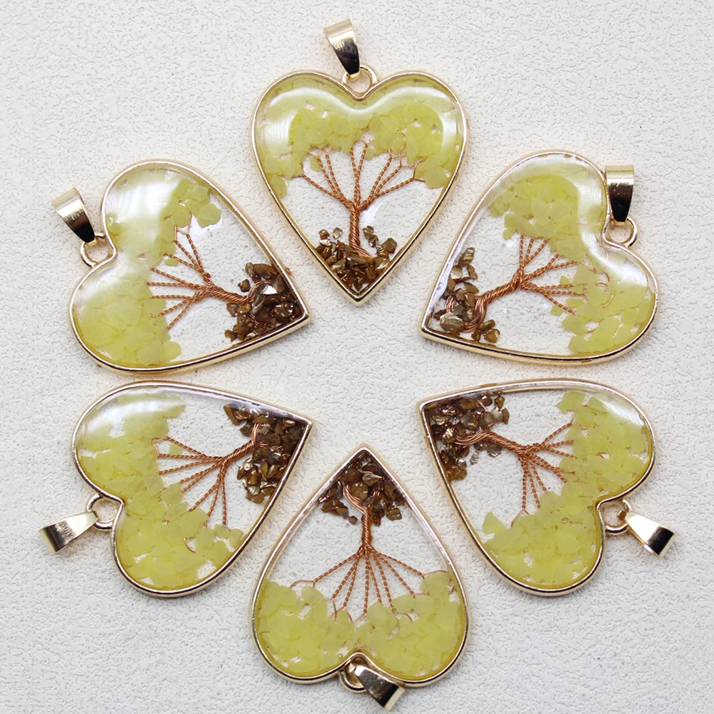 Five heart-shaped pendants with tree designs on a light gray background