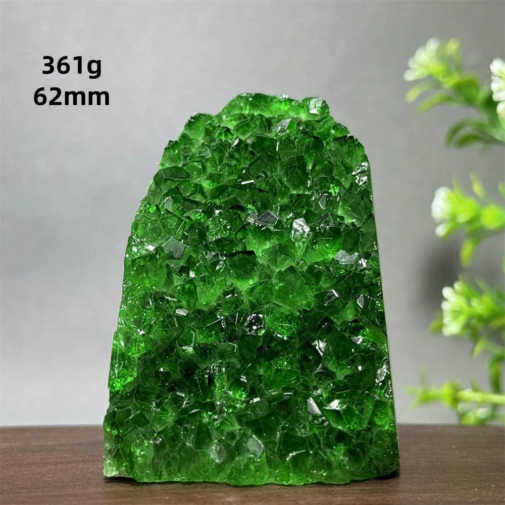 Green crystal rock on a wooden surface with a gray background