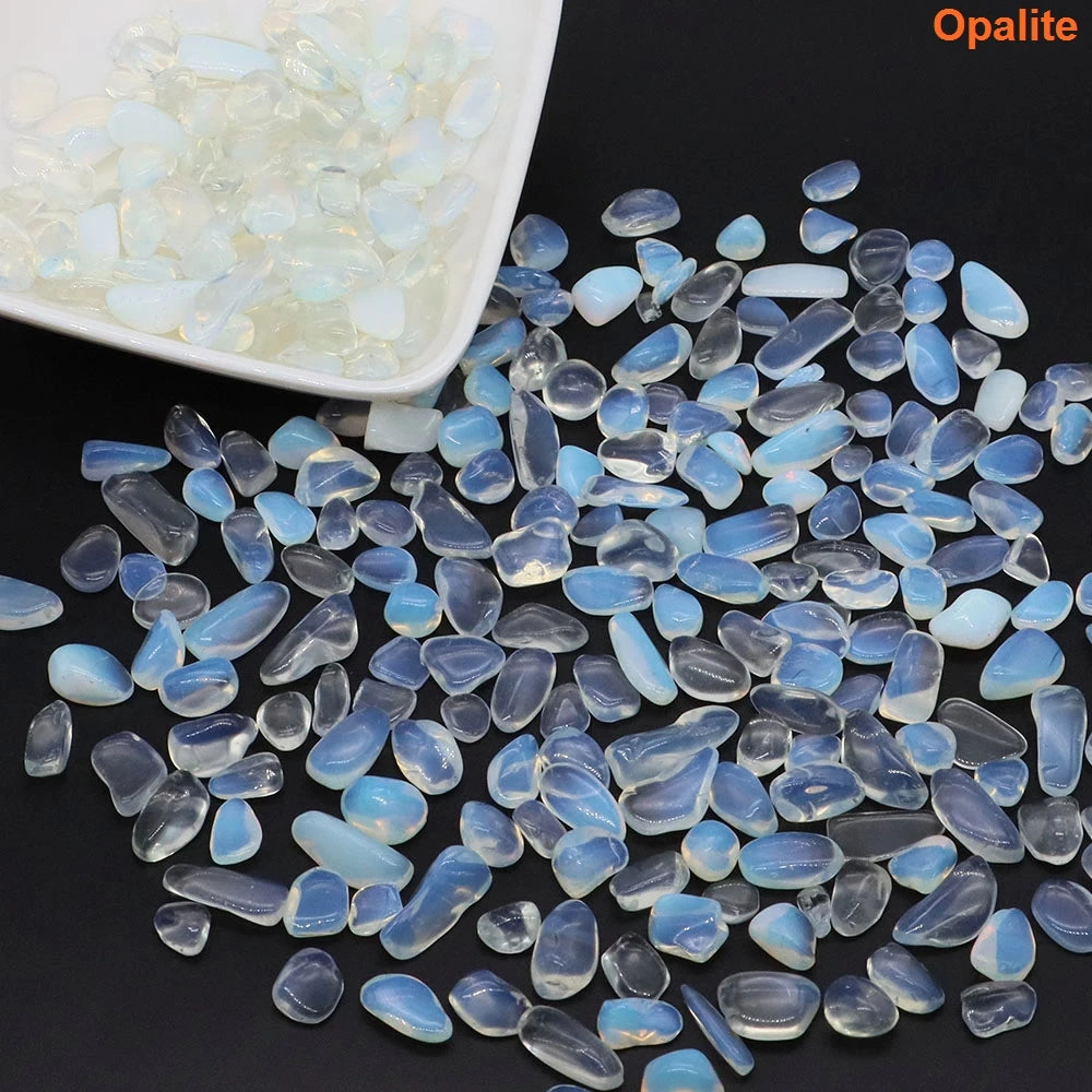 Opalite stones on a dark surface with a white container of opalite stones in the background.